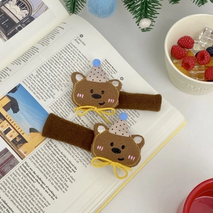 Detail of cute bear plush door handle cover with party hat on an open book page
