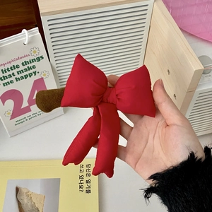 Detail of red satin bow door handle cover with long ribbons and plush base attachment
