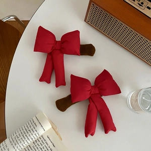 Macro shot of red satin bow door handle covers with brown plush edges on a desk