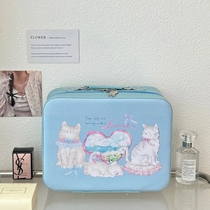 Detail of light blue cat illustration makeup bag with top handle on a display shelf
