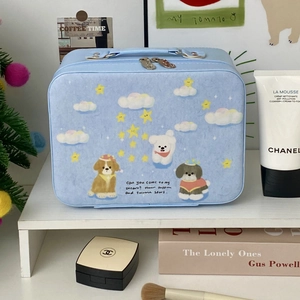 Detail of light blue vanity case with cartoon puppies and sturdy handle on white shelf