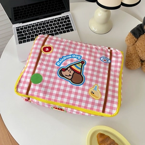 Cute pink checkered laptop sleeve with Rainbow Dog patch on a cozy workspace desk