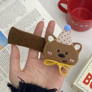Detail of cute plush bear hair clip with a polka dot hat and knit-wrapped clip surface