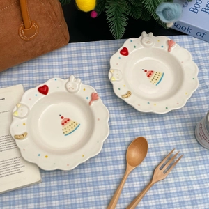 Macro detail of white ceramic dessert plates featuring embossed 3D cat and bunny relief