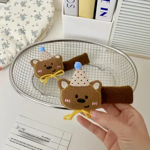 Detail of plush bear door handle covers with blue party hats and yellow ribbon bows