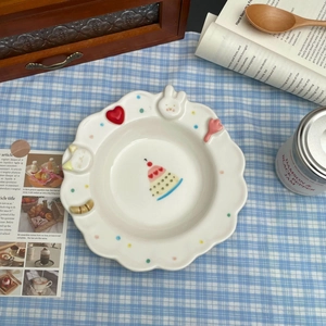 Detailed top view of a cream ceramic plate with 3D bunny and tulip edge decorations