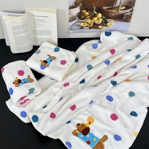 Detail of soft spotted dog embroidered bath towels with colorful polka dot patterns