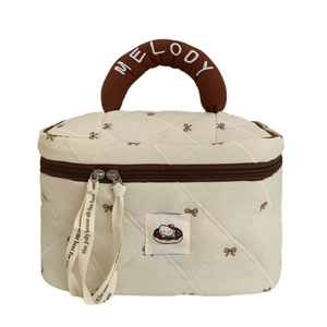 Quilted donut cosmetic bag in cream with brown trim and Melody embroidery handle