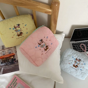 Close-up of quilted cotton makeup bags with cute dachshund embroidery and zip closure