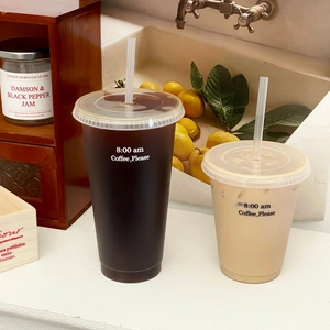 Wiederverwendbare Sommer-Kaffeebecher mit Strohhalmen und Text in heller Küchenumgebung