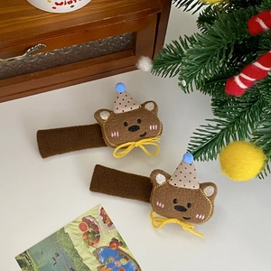 Detail shot of brown felt bear hair clips with polka dot hats in a cozy holiday setting