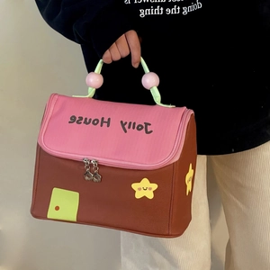 Detail of a house-shaped insulated lunch bag with a dual zipper and top handle design