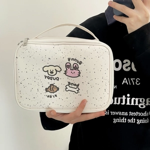 Detailed view of the cartoon pattern and texture on a cream waterproof makeup bag