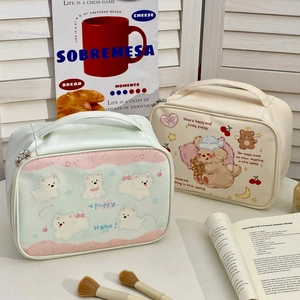Detail showing high-capacity travel makeup bags with cute puppy prints and handles