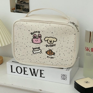 Close-up of beige waterproof makeup bag with cartoon patterns and silver metal zipper