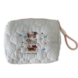Quilted blue makeup bag with cute dog embroidery and pink zipper handle for travel