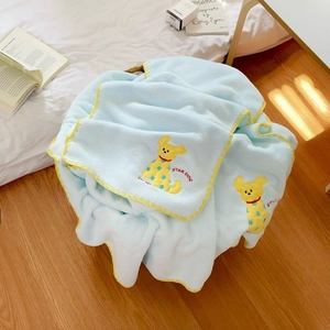 Nahaufnahme eines hellblauen Korallenvlies-Handtuchs mit gelbem Hundestickerei-Detail