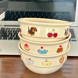 Detailed view of stacked cream-colored ceramic bowls with hand-painted cartoon illustrations