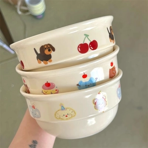 Detail of cream ceramic bowls set featuring cute cartoon dachshund and cherry illustrations