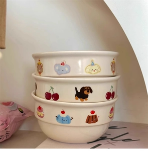 Detail of stacked cream ceramic bowls with hand-painted cartoon animals and dessert patterns