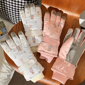 Detail of waterproof ski gloves featuring anti-slip palms and adjustable windproof cuffs