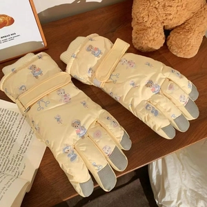 Detail of yellow winter gloves with bear print, velcro strap and non-slip fingertips