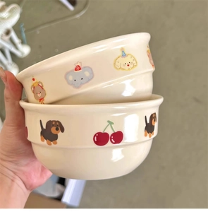 Detailed view of stacked cream ceramic bowls with hand-painted cartoon animals