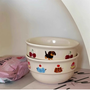 Detail of cream ceramic bowls featuring hand-drawn dachshund and dessert patterns
