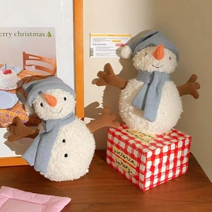 Detail of plush snowman set with blue knitted hats and scarves on cozy wooden tabletop