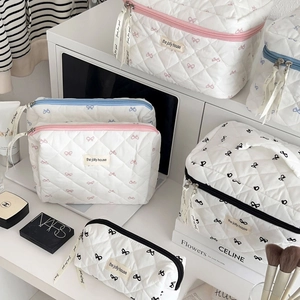Ensemble détaillé de trousses de maquillage matelassées blanches avec motifs de nœuds