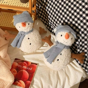 Plush snowman doll pair with blue knit hats and scarves on soft white bedding