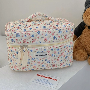 Detail of floral corduroy makeup bag with quilted texture and ribbon zipper pull