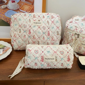 Quilted mint lamb style makeup bag set with cartoon bear patterns on wood desk