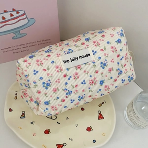 Detail of floral corduroy toiletry bag with quilted texture and brand label
