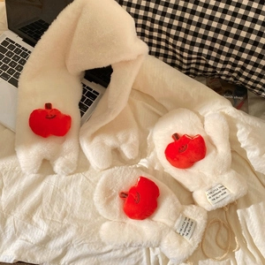 Detail of warm white plush gloves with cute red apple patch and soft winter texture