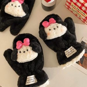Detail of plush black puppy mitten with cartoon face and pink bow in lifestyle setting