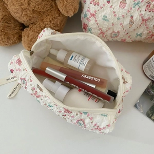 Close-up of floral quilted makeup bag showing spacious interior with beauty products