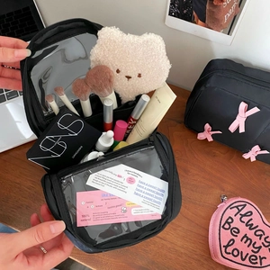 Large black makeup bag with bow detail and transparent compartments for cosmetics