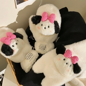 Detail of plush dog gloves with soft faux fur, black ears and a cute pink bow decoration
