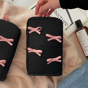 Cute black cosmetic bag with pink bows and handle for skincare and toiletries storage