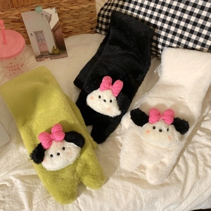 Close-up of plush winter scarves with cute cartoon dog heads and pink bowknot details