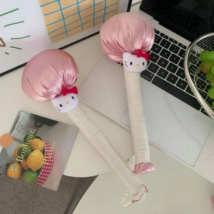 Pink satin cartoon cat mugwort massage hammer with white cotton rope handle in home setting