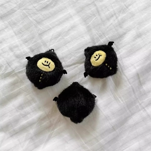 Set of three black fluffy plush devil lemon keychains with smiley faces and small wings