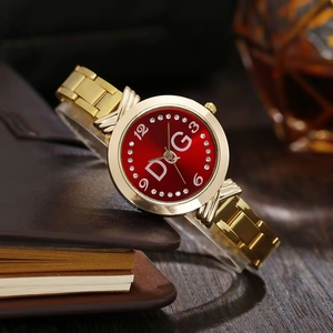Macro detail of red watch face with D&G logo and crystal indices on gold band