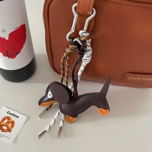 Detail of dachshund leather charm with woven rope and silver clasp on a brown tote bag