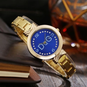 Detail of luxury gold steel watch with royal blue dial and rhinestones on leather background