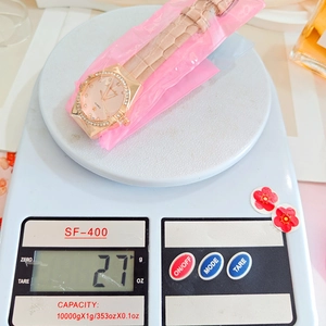 Detail showing lightweight women's quartz watch weighing 27g on a digital scale