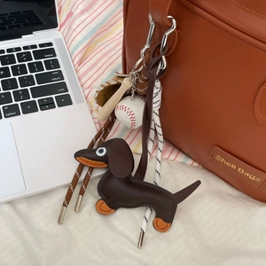 Cute leather dachshund dog charm with strap used as a decorative accessory for bags