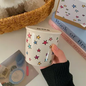 Star pattern ceramic mug with Shine like the stars quote shown in a hand-held view