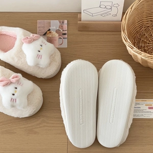Detailed view of cream plush slippers with cartoon cat star and non-slip rubber soles